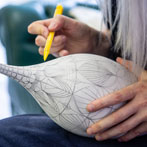 Rhian Malin decorating a mandala bottle in her workshop 2019